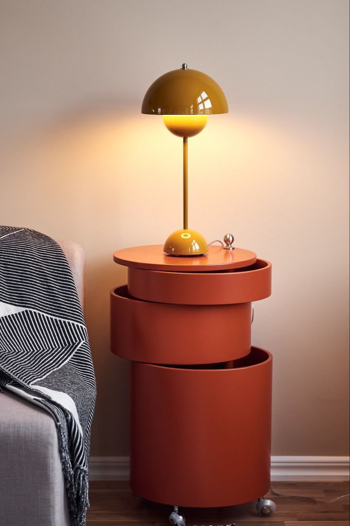 Die gelbe Flowerpot Tischleuchte und der orangefarbene Beistelltisch von Verpan sorgen für aufregende Kontraste im neutral gestalteten Wohnzimmer.