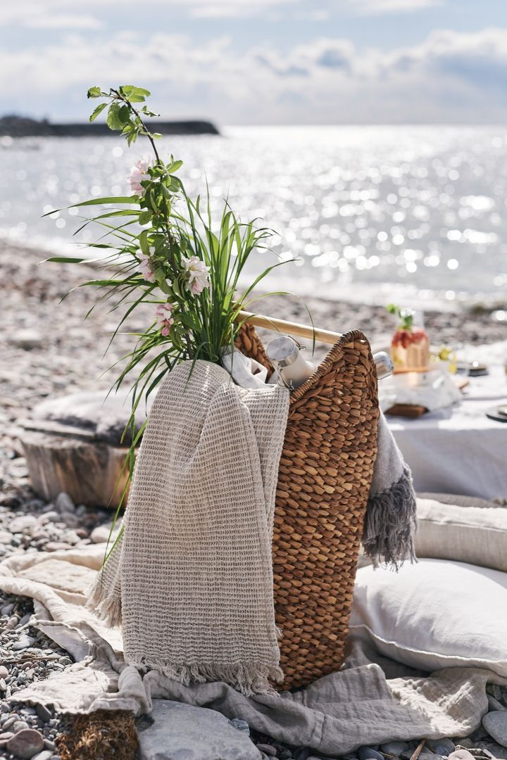 Picknickkorb mit Decken und Thermoskanne für ein Picknick am Strand.