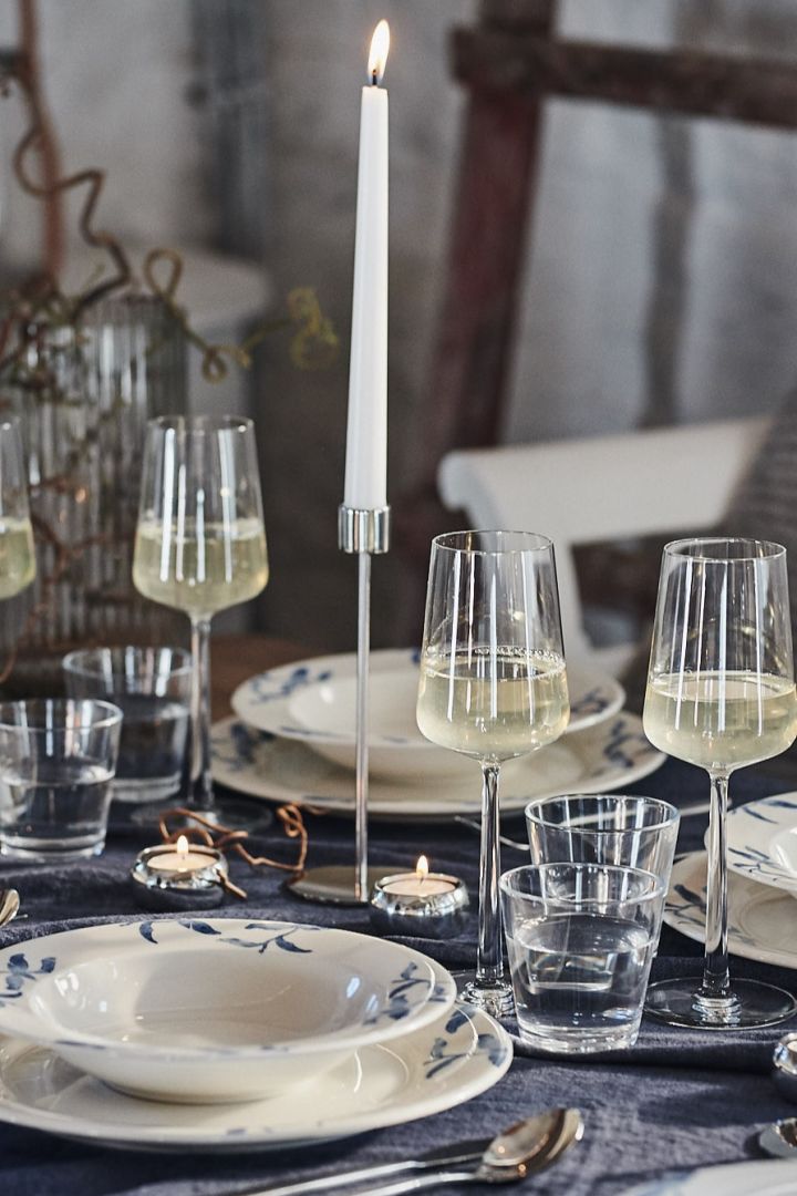 Weiße Weingläser von Essence verleihen diesem blau-weiß gedeckten Tisch zusammen mit verchromten Kerzenhaltern von Cooee Design einen eleganten Look. 