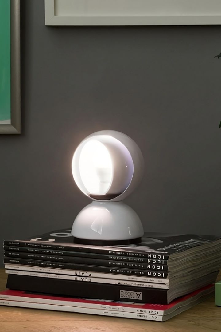 Die Leuchte Eclisse von Artemide steht auf einem Bücherstapel. 