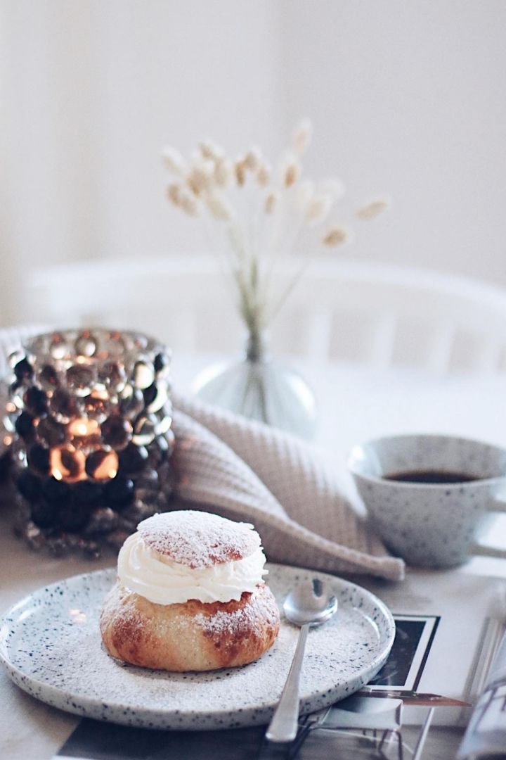 Zu dem beliebtesten schwedischen Gebäck gehören auch Semlor. Hier sehen Sie eine auf einem Poppi-Teller von Olsson & Jensen vor einer Poppi-Tasse im Zuhause der schwedischen Influencerin @picsbyellen.