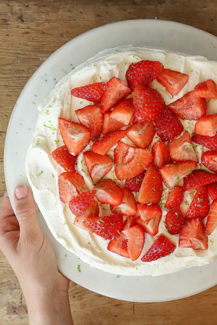 Frida von Baka med Frida garniert ihre schwedische Erdbeertorte neben Erdbeeren zusätzlich mit geriebener Limette vor dem Servieren.