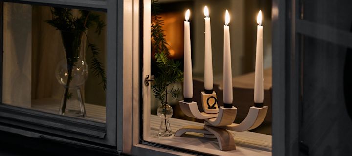 Ein typisch skandinavischer Kerzenhalter wie der Nordic Light Kerzenhalter von Design House Stockholm, der hier in einem offenen Fenster steht, ist ein Muss zu jedem schwedischen Weihnachtsfest und oftmals ein wichtiger Bestandteil von skandinavischen Weihnachtsgeschichten.