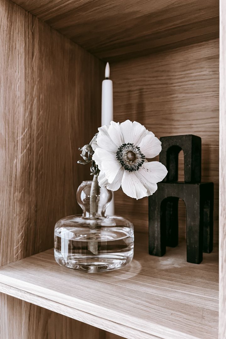 Deko-Ideen für Ihr Bücherregal: Inspiration aus dem Haus von Anela Tahirovic @arkihem, wo eine Schnittblume in einer hübschen Marimekko-Vase einen lebendigeren Eindruck auf Ihrem Bücherregal erzeugt.