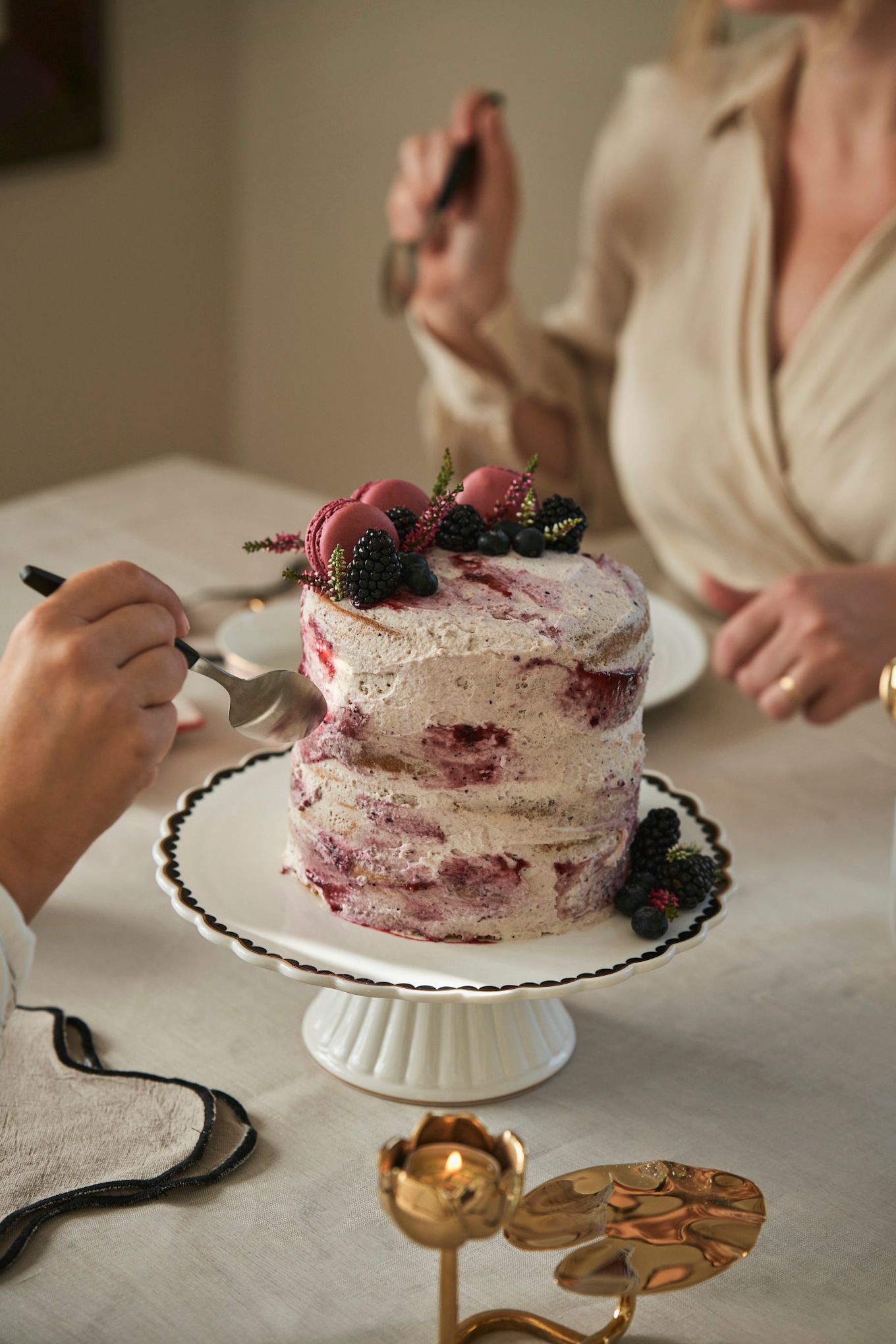 Feiern Sie den Galentine's Day mit einer Teeparty. Hier sehen Sie einen speziellen Galentine's Day-Kuchen mit Beeren der Saison und Macarons. 