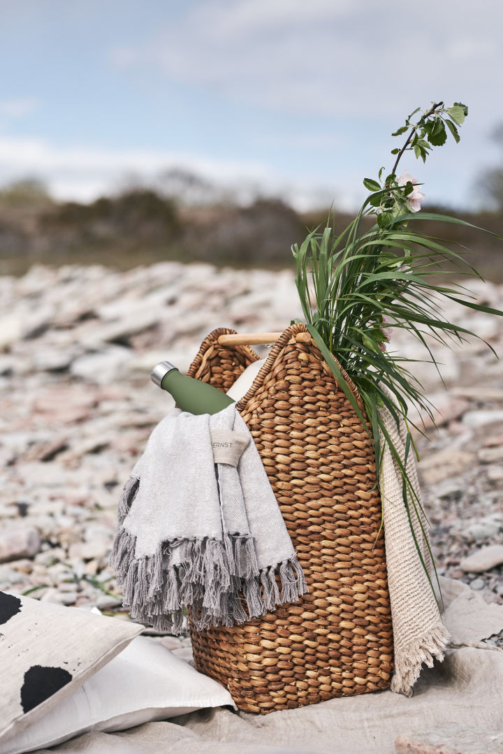 Ein Sommerfavorit ist der Picknickkorb von Oyoy, der mit einer kuscheligen Decke gefüllt ist, um sich nach einem Bad im Meer warm zu halten.