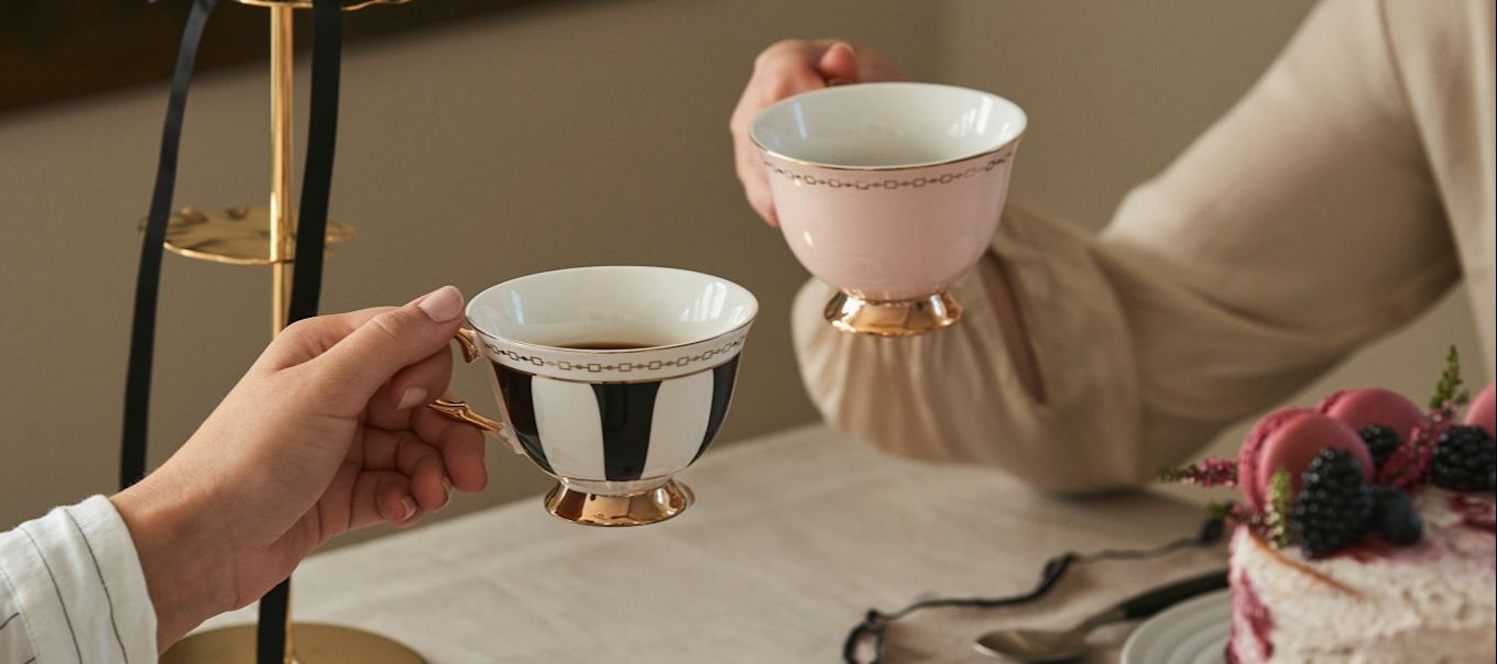 Feiern Sie den Galentine's Day mit einem traditionellen Nachmittagstee mit Ihren Freundinnen. Hier sehen Sie zwei Freundinnen, die mit Teetassen von Hilke anstoßen.