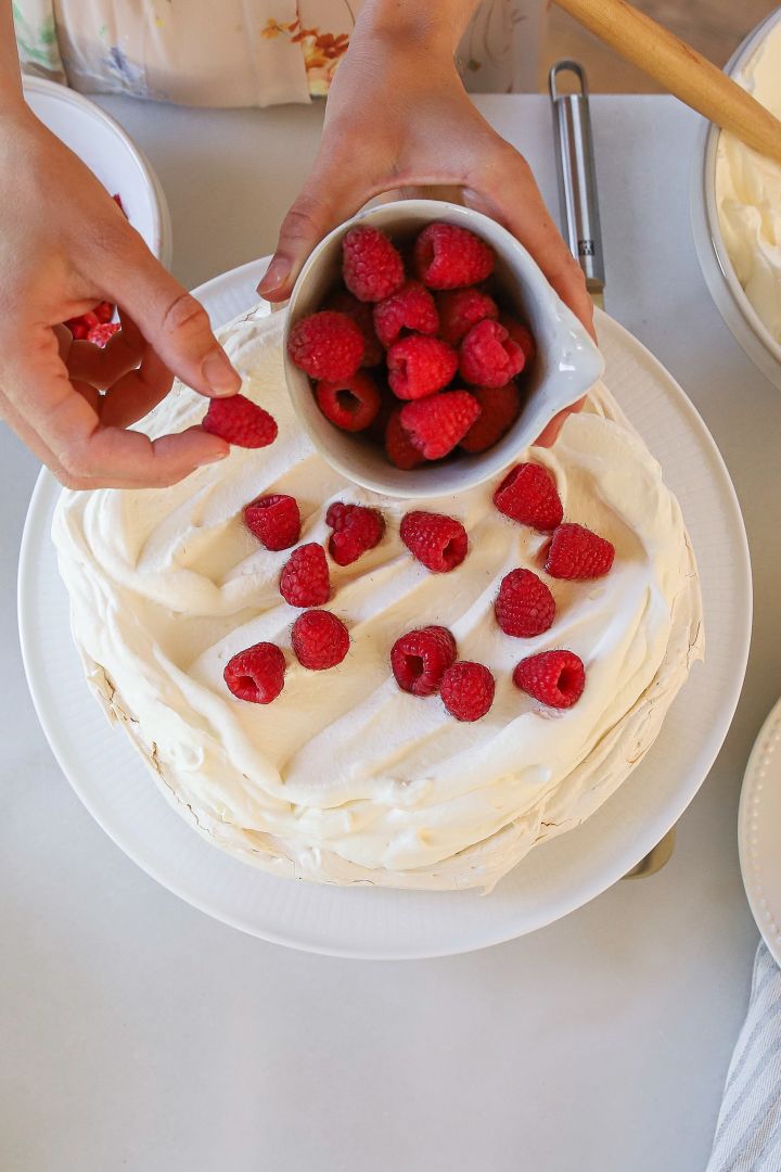 Die schwedische Back-Influencerin Baka med Frida backt nicht nur die klassische schwedische Erdbeertorte zum Mittsommer, sondern auch einen köstlichen Baiser-Kuchen, welchen Sie hier auf einer Swedish Grace-Kuchenplatte von Rörstrand angerichtet hat und mit Himbeeren dekoriert.